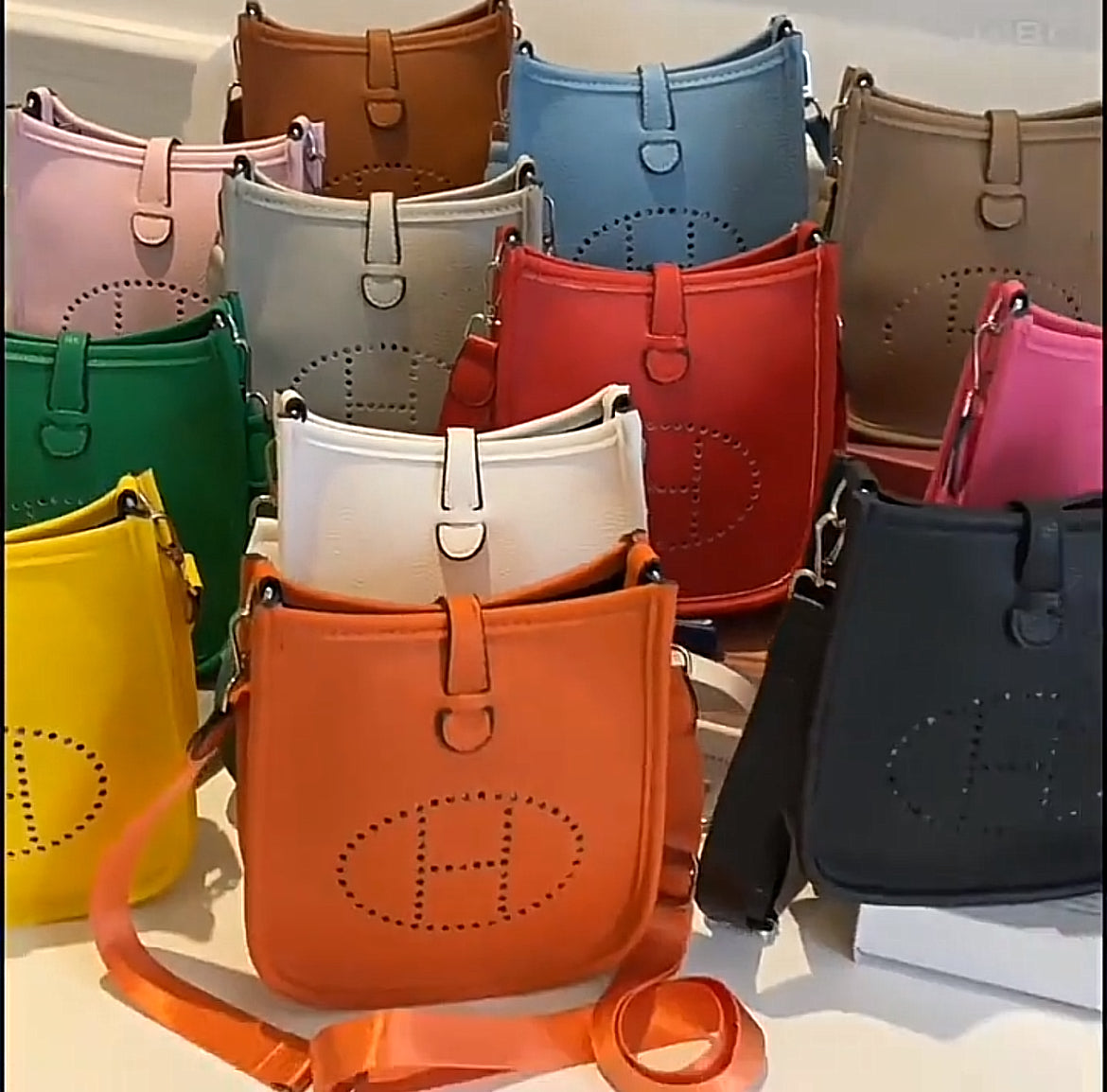 Leather crossbody with hole poke H logo.