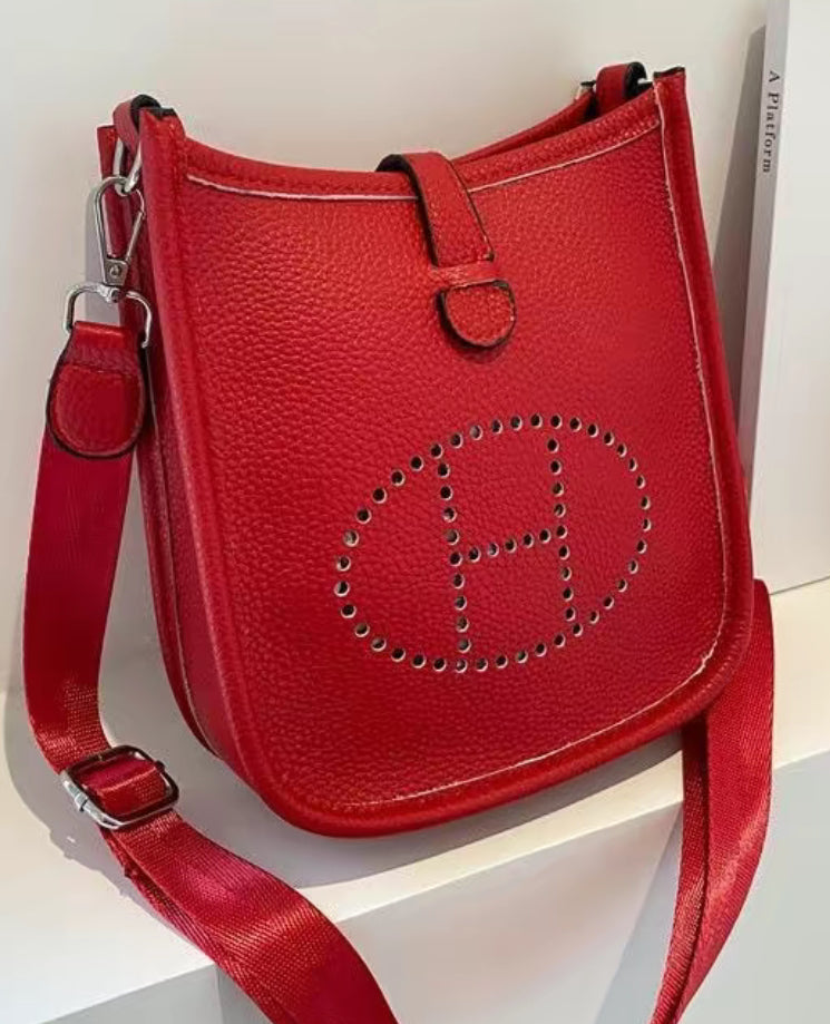 Leather crossbody with hole poke H logo.