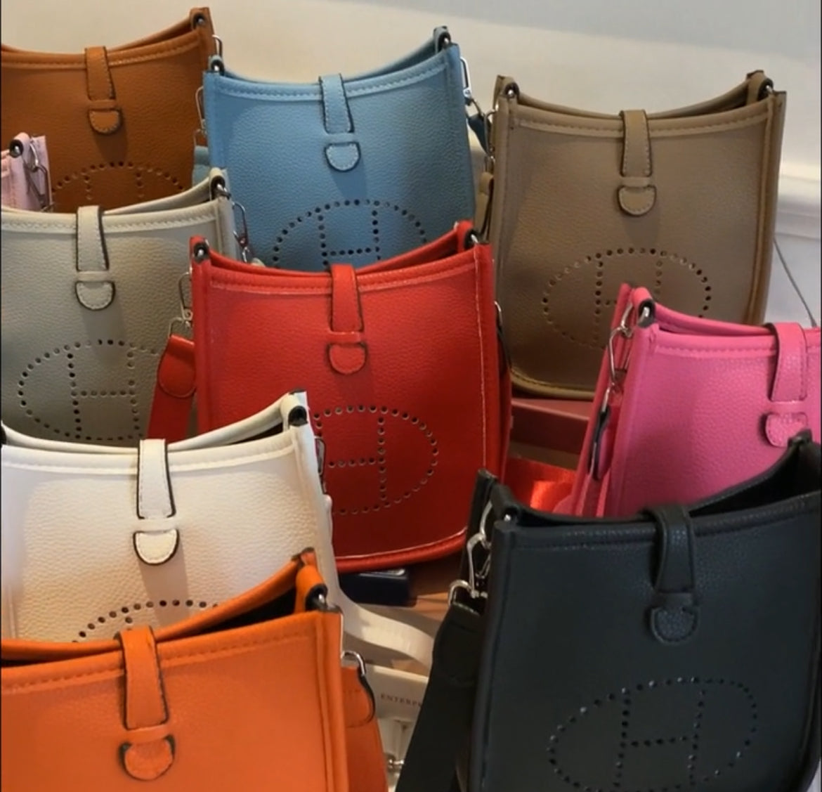 Leather crossbody with hole poke H logo.