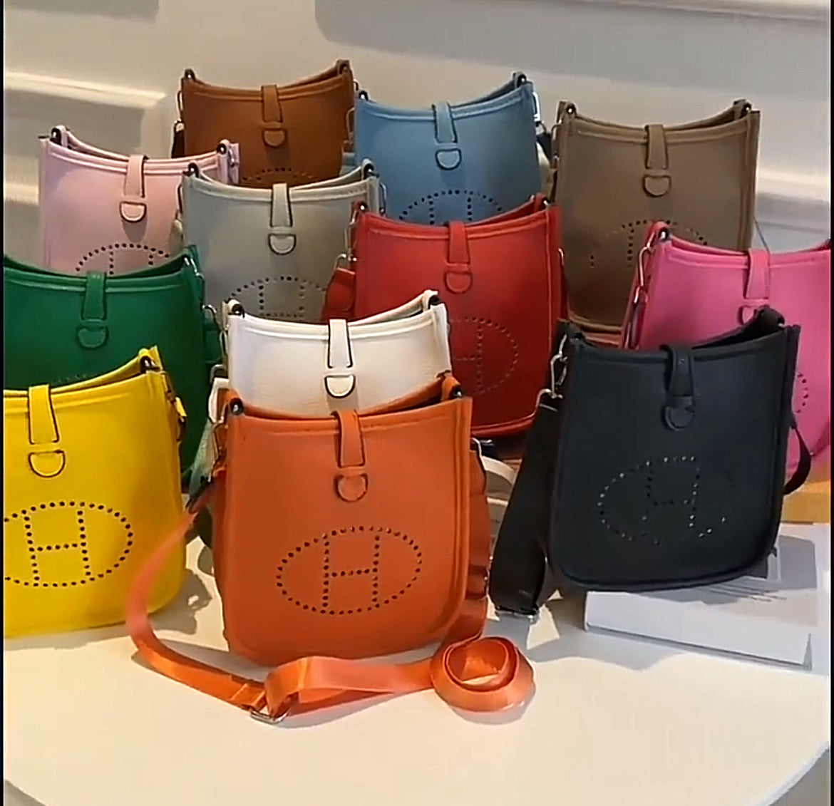 Leather crossbody with hole poke H logo.