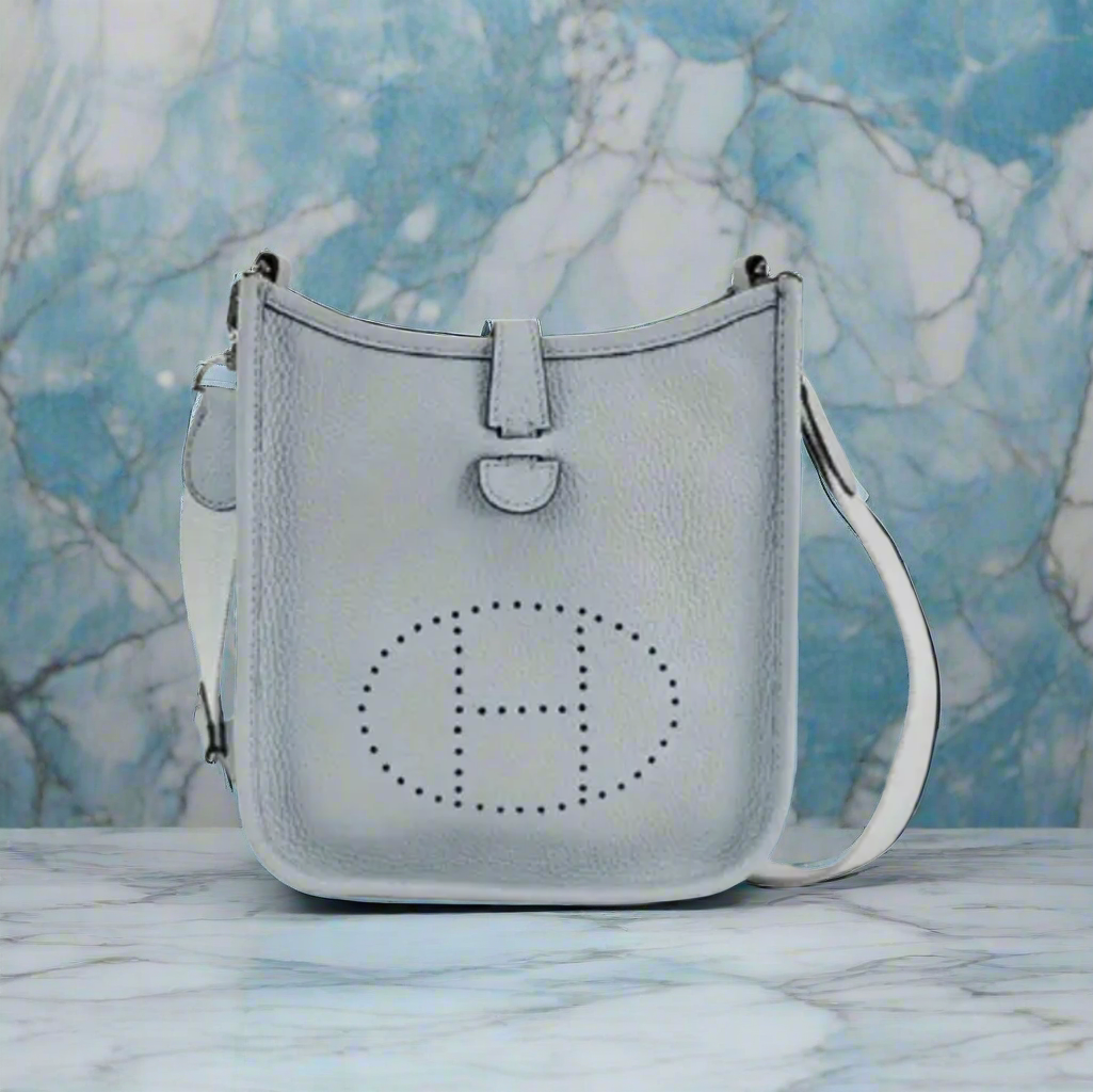 Leather crossbody with hole poke H logo.