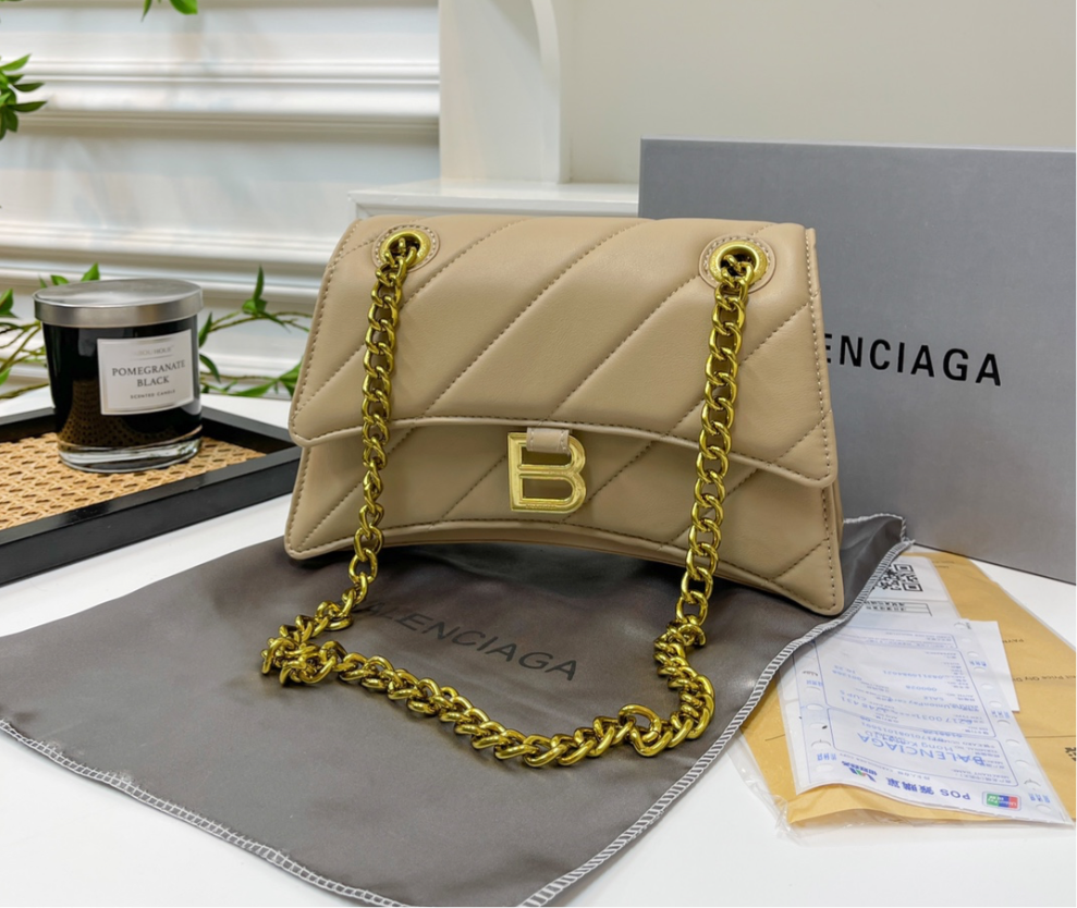 Solid light beige (large) leather hourglass handbag with diagonal lines design, gold hardware, gold chain and gold B logo on the front. Crossbody style in size large (wider & taller than standard size)