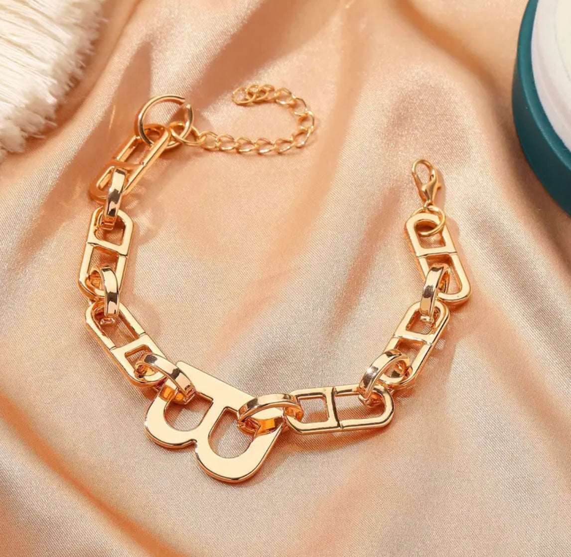 Gold chain necklace on peach fabric background
