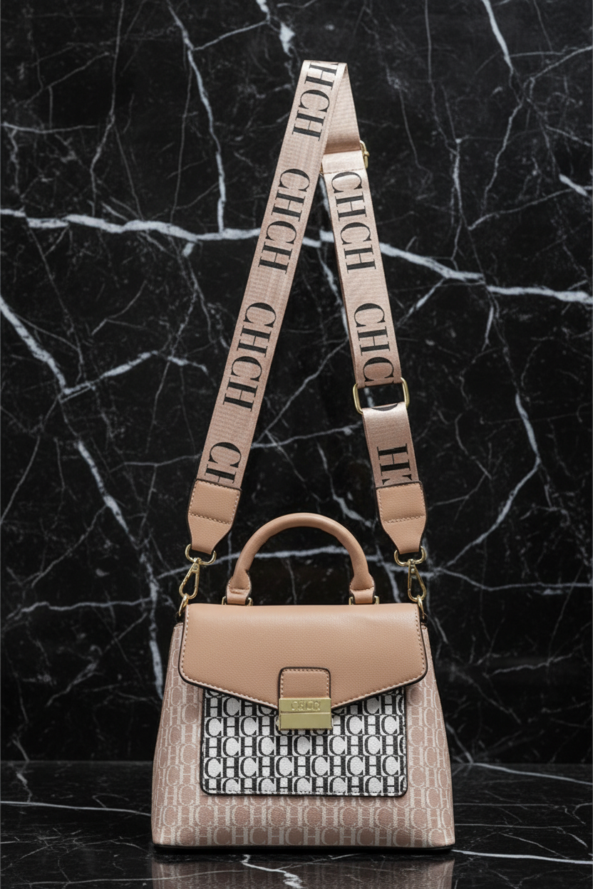 Tan color leather crossbody Handbag with CHCH logo monogram pattern repeated throughout, leather handle, and matching CHCH lettering on the long strap. There is a marble background. 