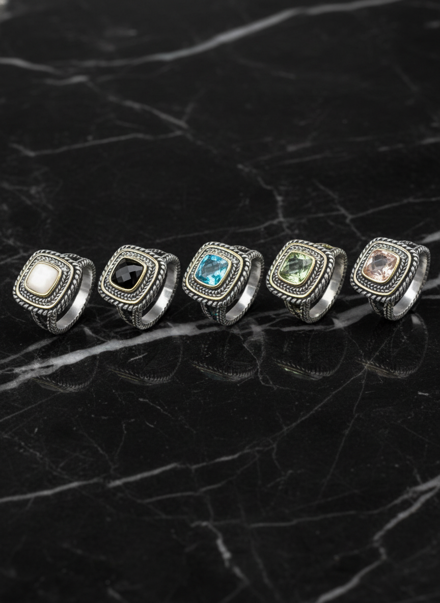 Set of five rings with different gemstones on a black background