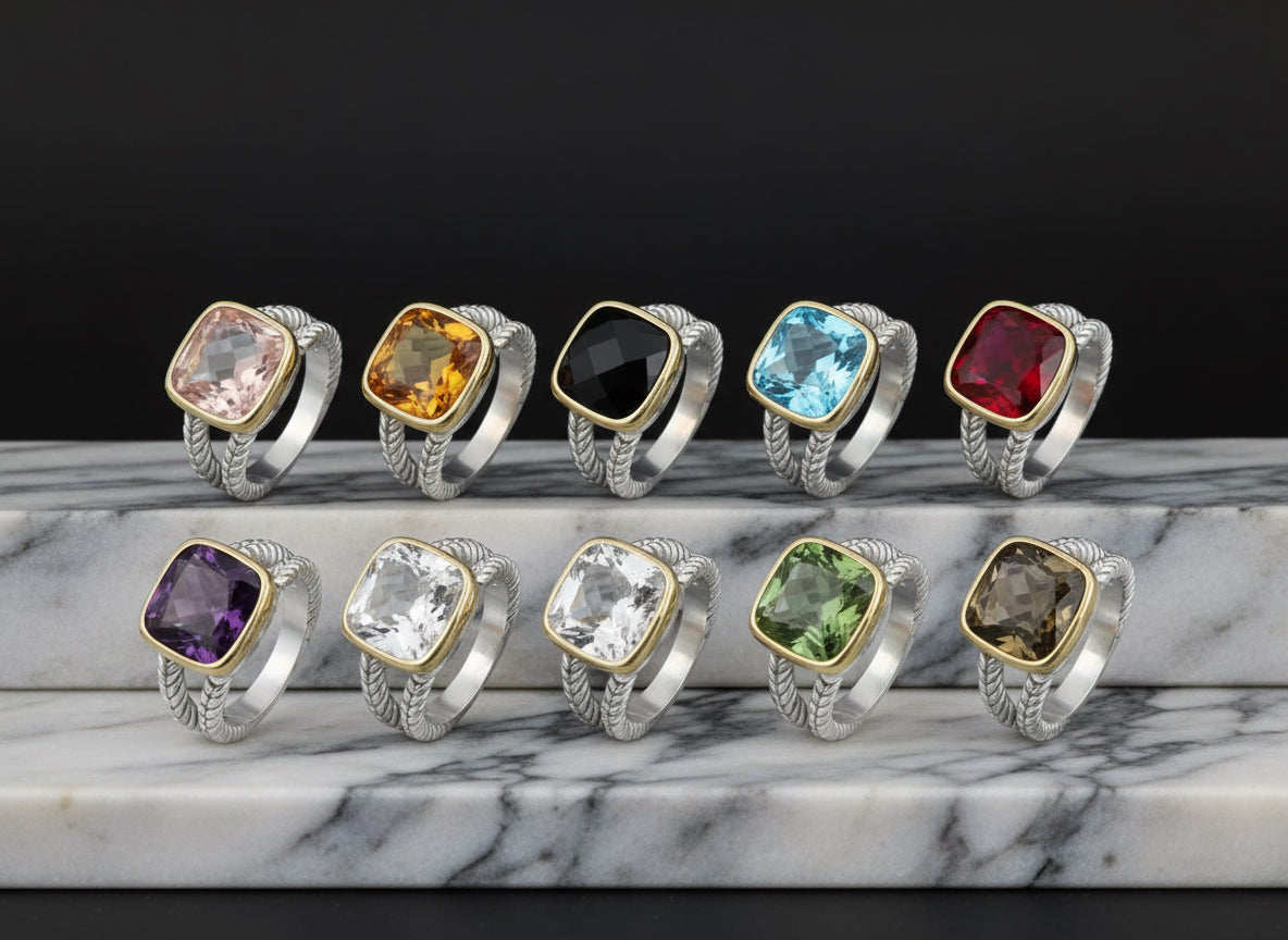 Set of silver rings with colorful gemstones on a light blue background