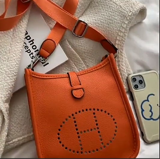 Leather crossbody with hole poke H logo.
