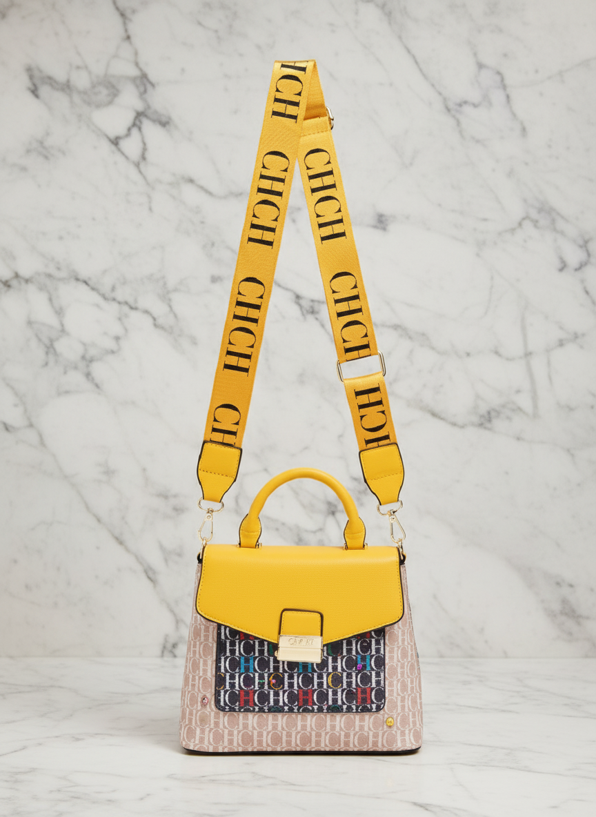 Yellow handbag with a patterned base and matching strap on a white background