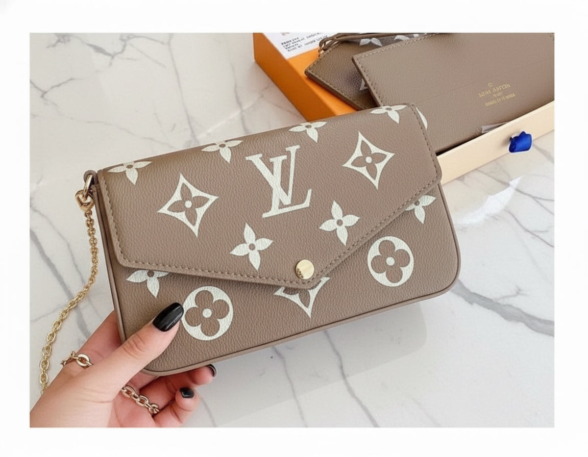 Louis Vuitton monogram handbag held by a hand on a wooden surface