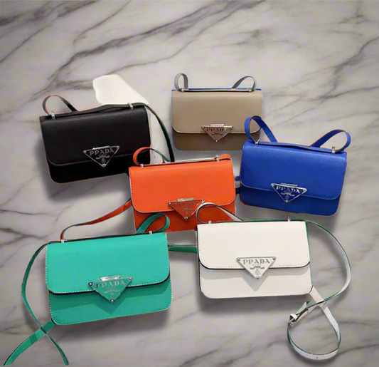 Collection of Prada handbags in various colors on a marble surface