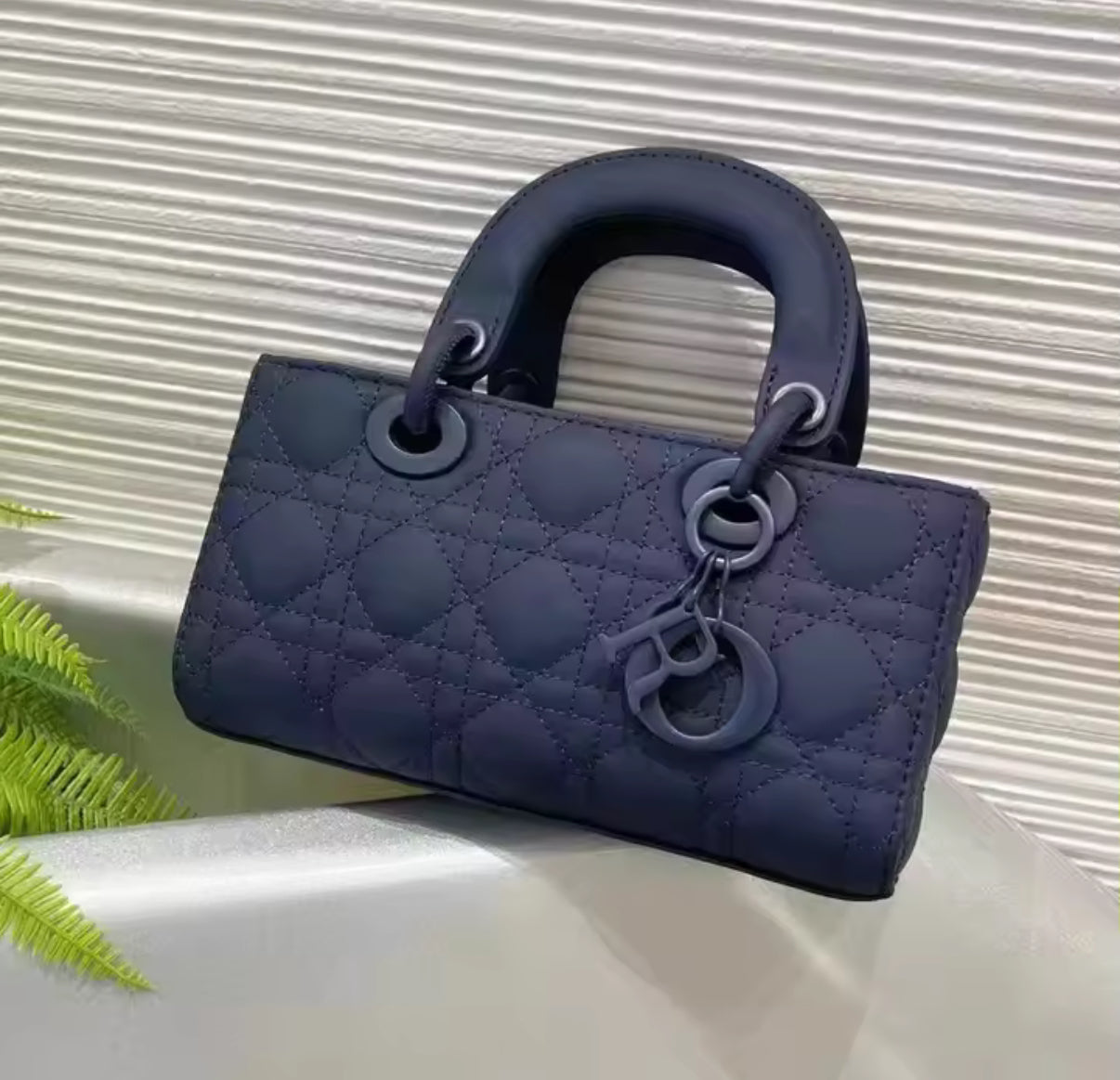 Matte dark navy blue rectangular quilted stitching leather bag with double handles.  