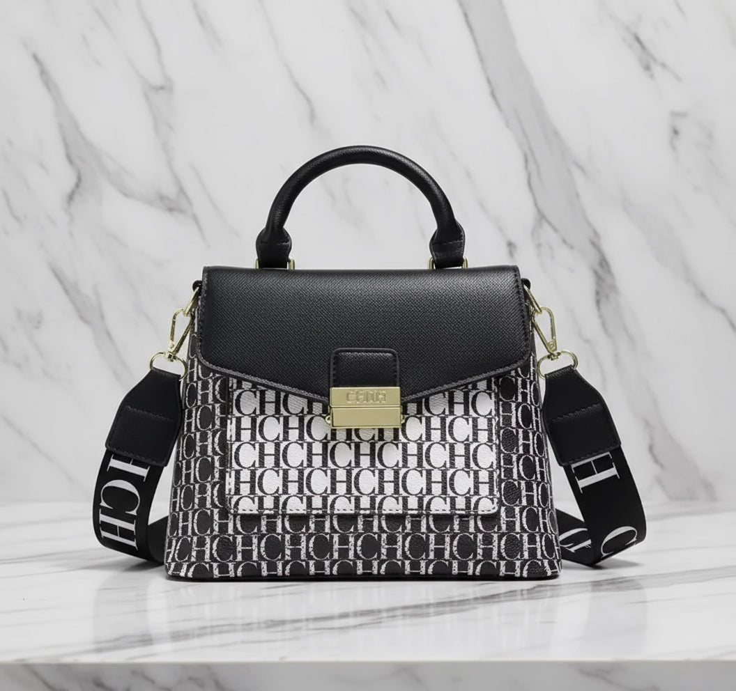 Black handbag with a patterned strap on a white background